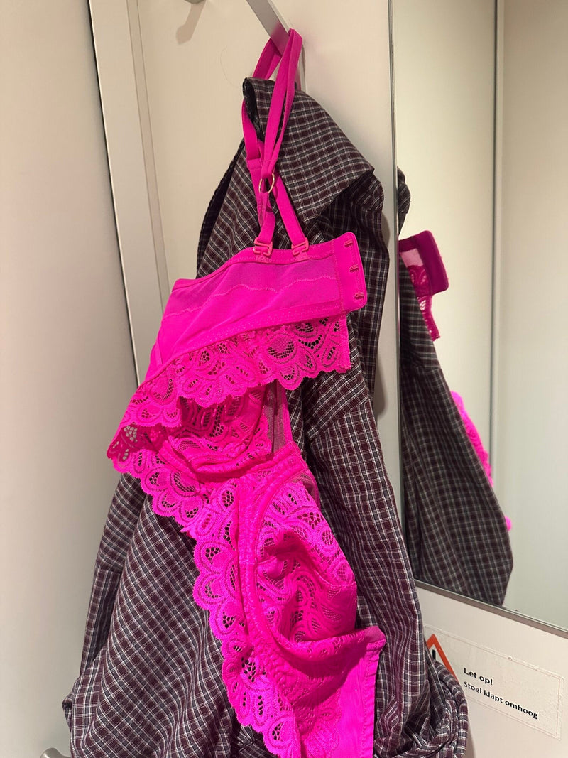 Roze kanten bh van Jolanda, opgehangen in de bus van het bevolkingsonderzoek